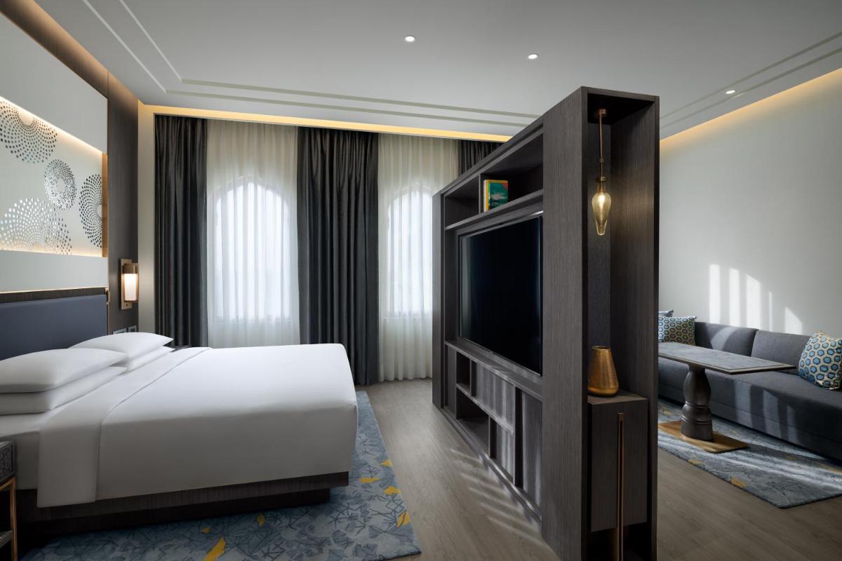 a bedroom with a bed and a tv and a couch at Hyatt Regency Jaipur Mansarovar in Jaipur a bedroom with a bed and a tv and a couch at Hyatt Regency Jaipur Mansarovar in Jaipur