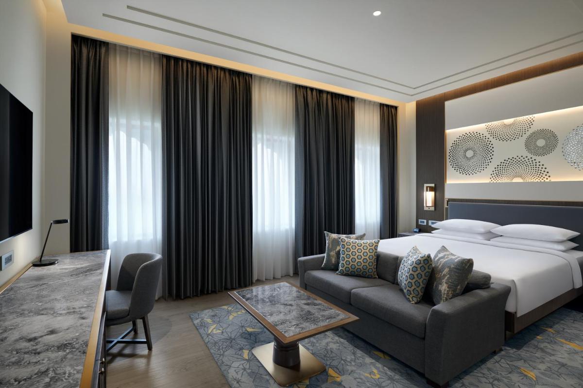 a hotel room with a bed and a couch at Hyatt Regency Jaipur Mansarovar in Jaipur a hotel room with a bed and a couch at Hyatt Regency Jaipur Mansarovar in Jaipur