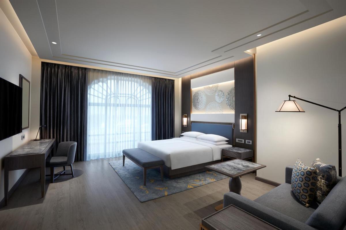 a hotel room with a bed and a desk at Hyatt Regency Jaipur Mansarovar in Jaipur a hotel room with a bed and a desk at Hyatt Regency Jaipur Mansarovar in Jaipur