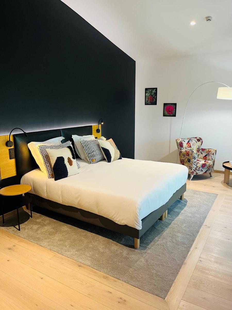 une chambre avec un lit avec un mur noir dans l'établissement Le Château De Beaulieu, à Busnes
