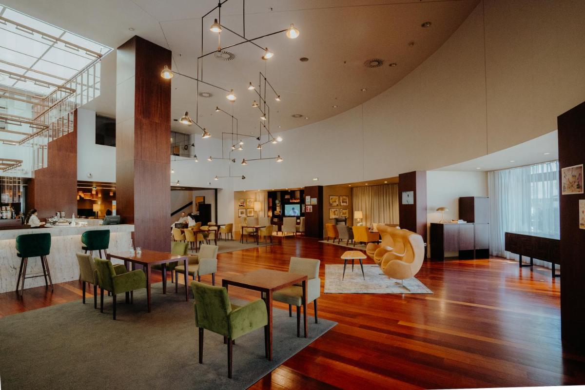uma sala de jantar com mesas e cadeiras em um prédio em Gaia Residence em Vila Nova de Gaia