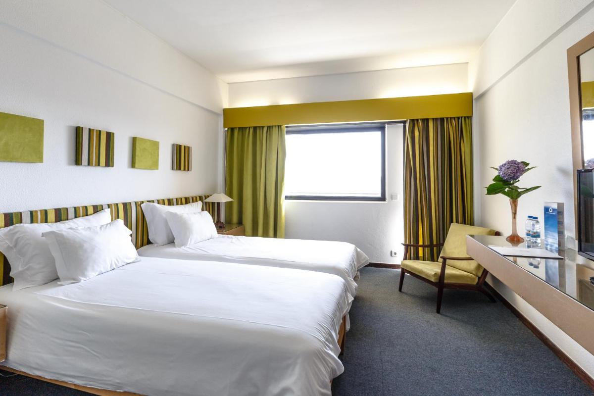 um quarto de hotel com duas camas e uma janela em Hotel Golf Mar em Maceira