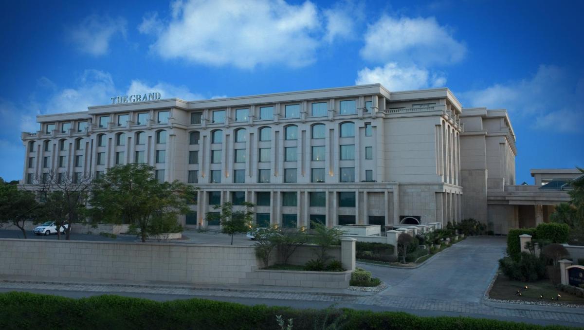 a large white building with a lot of windows at The Grand New Delhi in New Delhi a large white building with a lot of windows at The Grand New Delhi in New Delhi