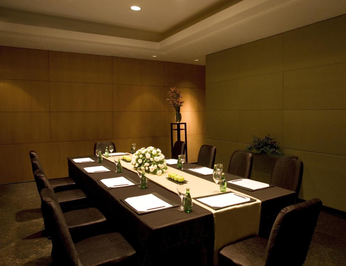 a dining room with a long table and chairs at The Grand New Delhi in New Delhi a dining room with a long table and chairs at The Grand New Delhi in New Delhi