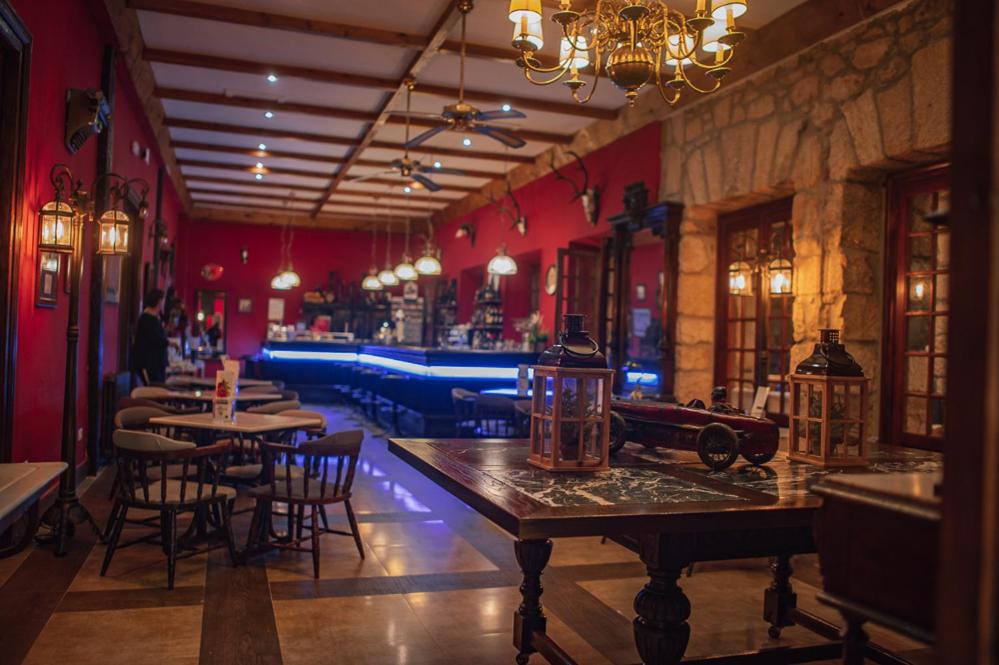 Un restaurante con paredes rojas, mesas y sillas. en Balneario de Corconte, en Cabañas de Virtus