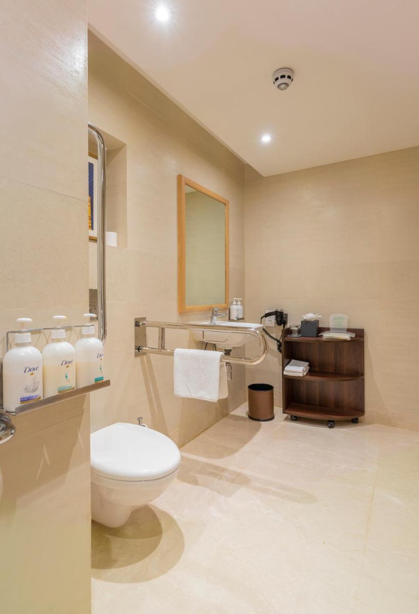 a bathroom with a toilet and a sink at Holiday Inn Agra MG Road an IHG Hotel in Agra