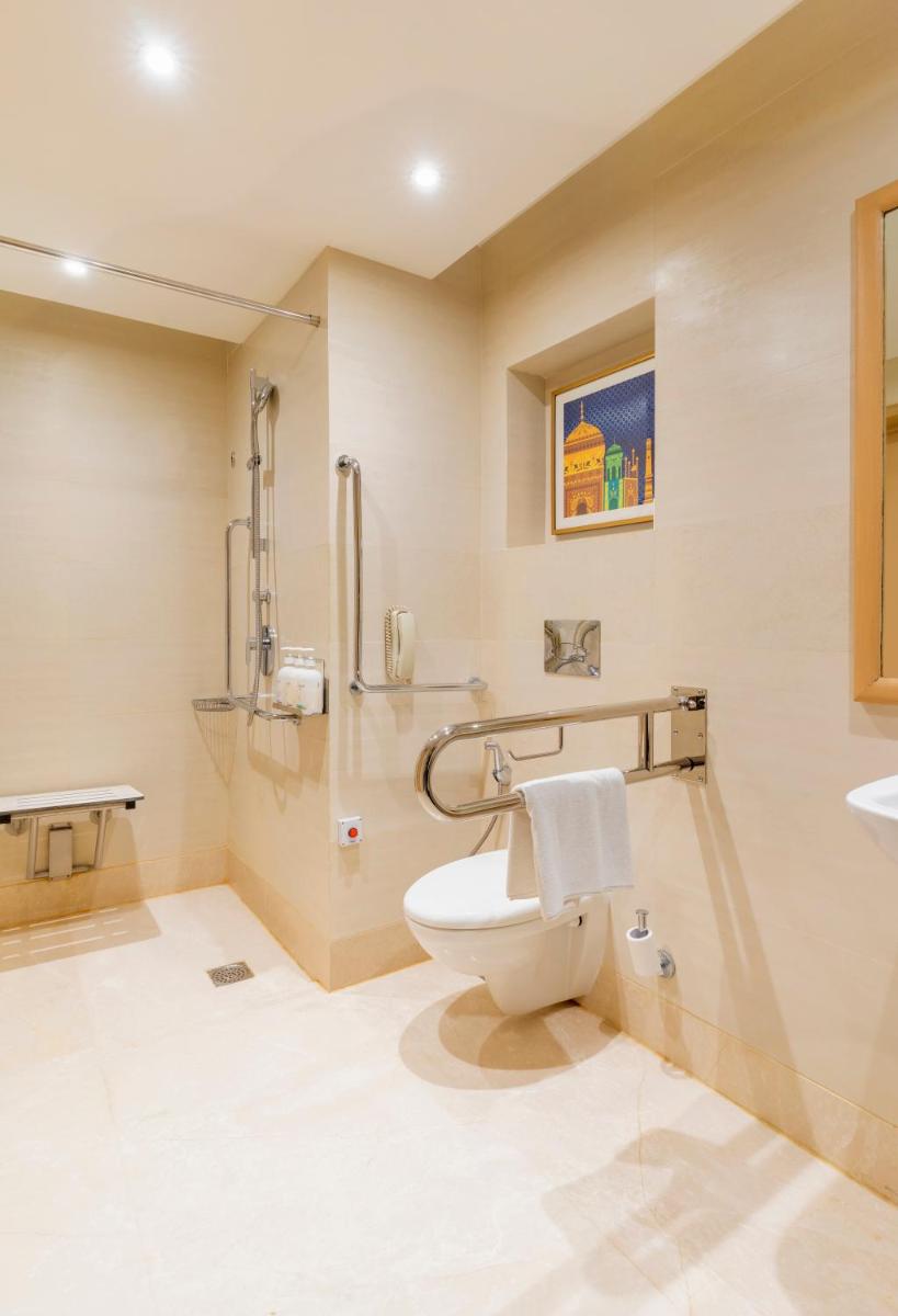 a bathroom with a toilet and a sink at Holiday Inn Agra MG Road an IHG Hotel in Agra