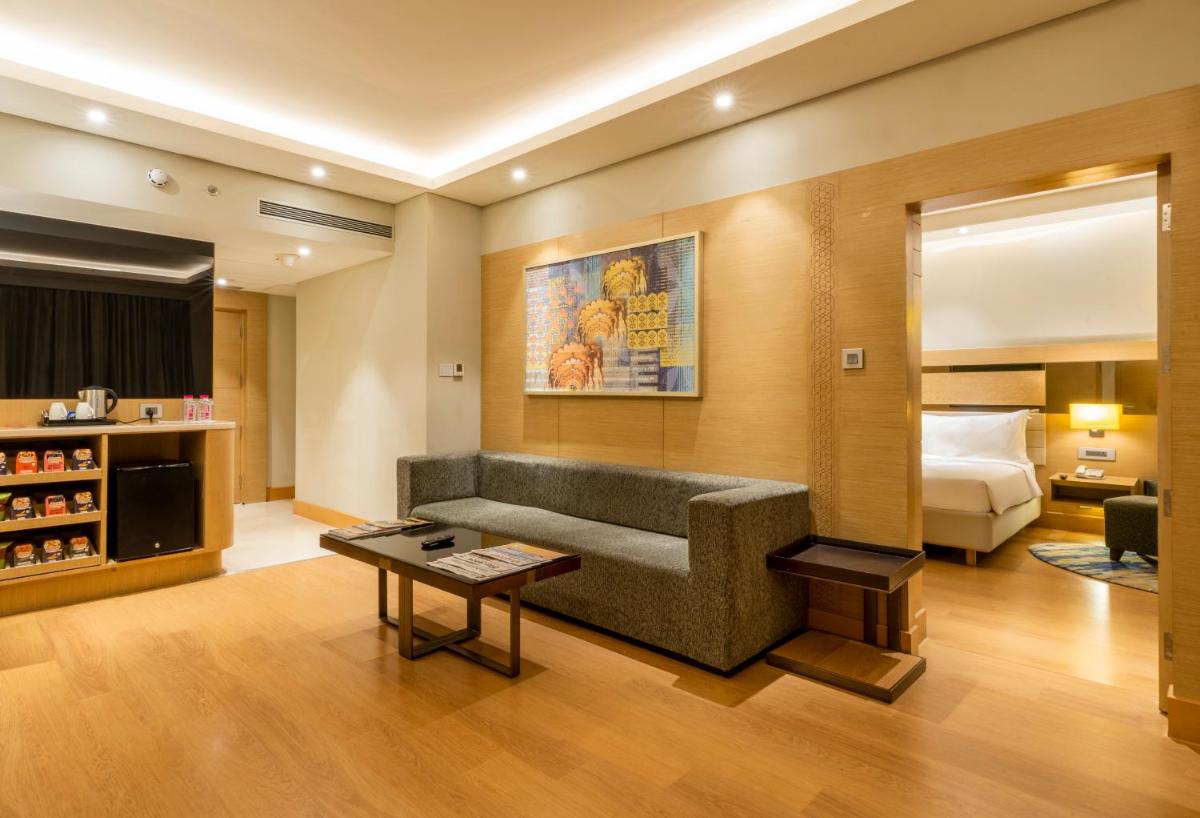 a living room with a couch and a bed at Holiday Inn Agra MG Road an IHG Hotel in Agra
