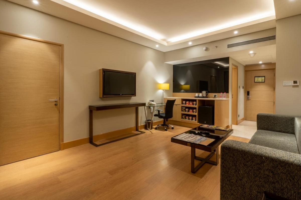 a living room with a couch and a television at Holiday Inn Agra MG Road an IHG Hotel in Agra