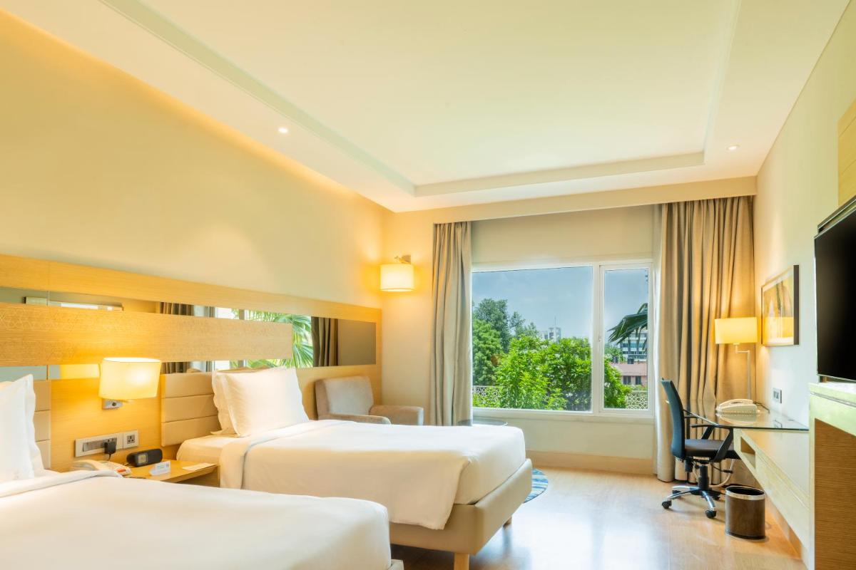 a hotel room with two beds and a window at Holiday Inn Agra MG Road an IHG Hotel in Agra