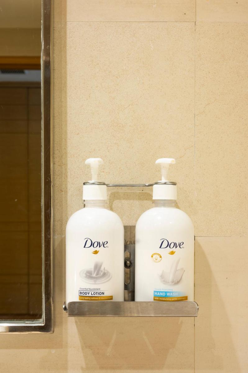 two bottles ofodorizers sitting on a shelf in a bathroom at Holiday Inn Agra MG Road an IHG Hotel in Agra