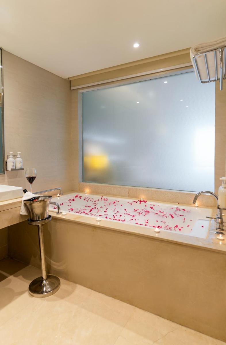 a bathroom with a tub covered in pink confetti at Holiday Inn Agra MG Road an IHG Hotel in Agra