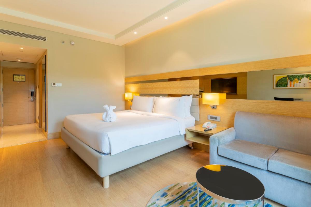 a hotel room with a bed and a couch at Holiday Inn Agra MG Road an IHG Hotel in Agra
