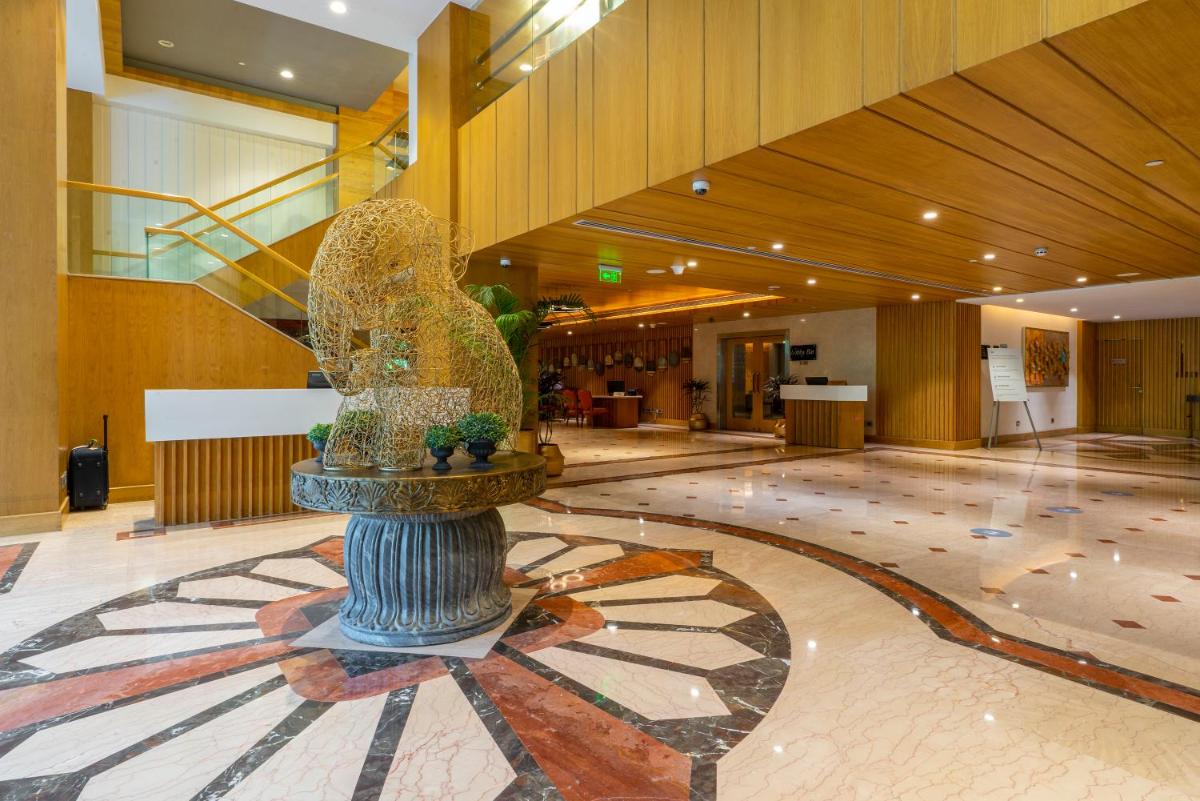 a lobby with a fountain in the middle of a building at Holiday Inn Agra MG Road an IHG Hotel in Agra