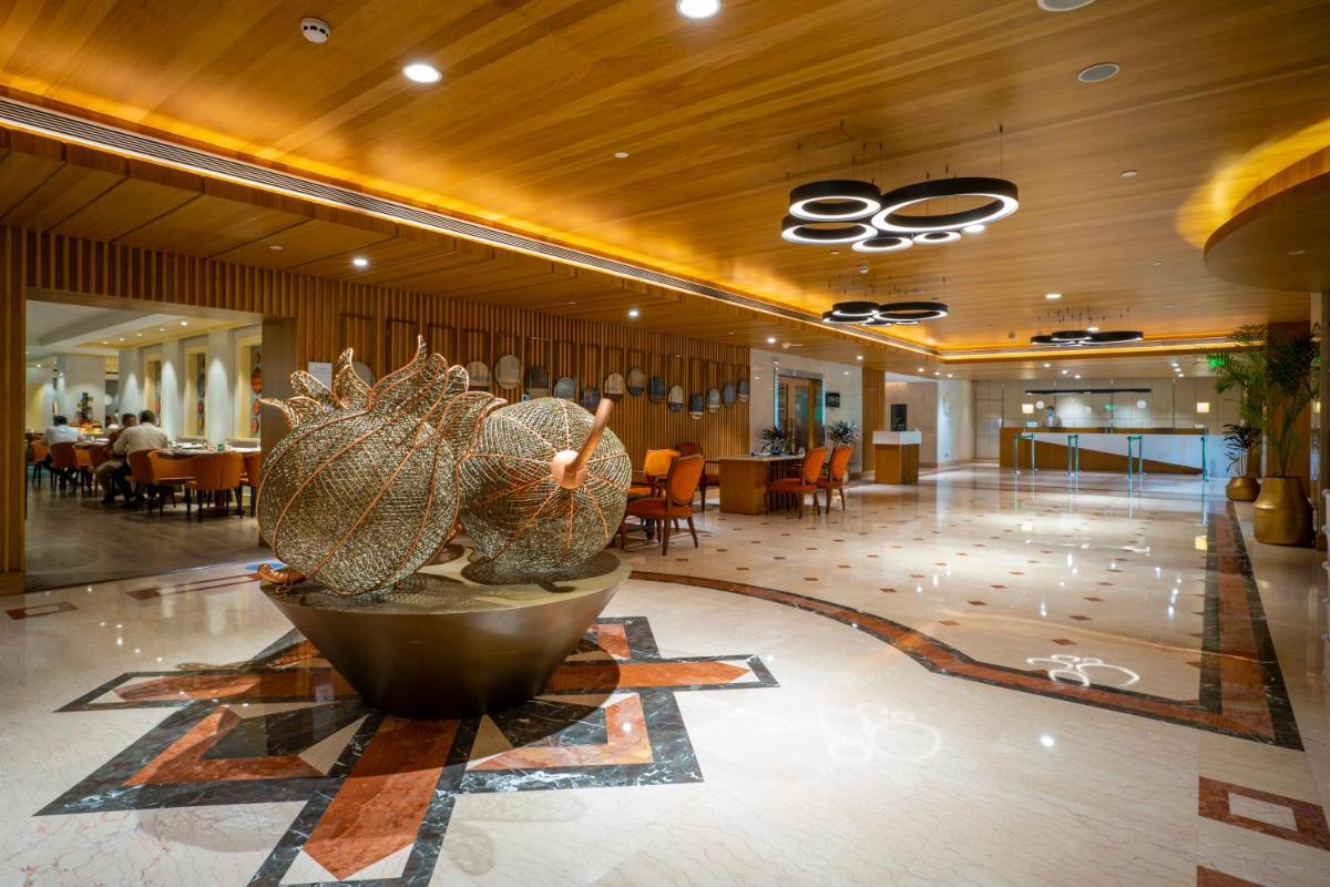 a lobby with a large pineapple sculpture in the middle at Holiday Inn Agra MG Road an IHG Hotel in Agra