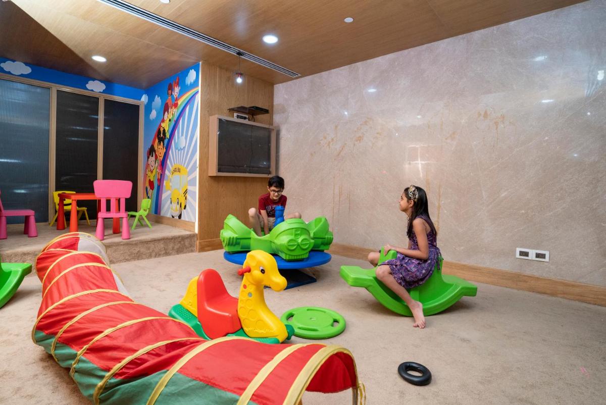 a woman and a child playing in a play room at Holiday Inn Agra MG Road an IHG Hotel in Agra