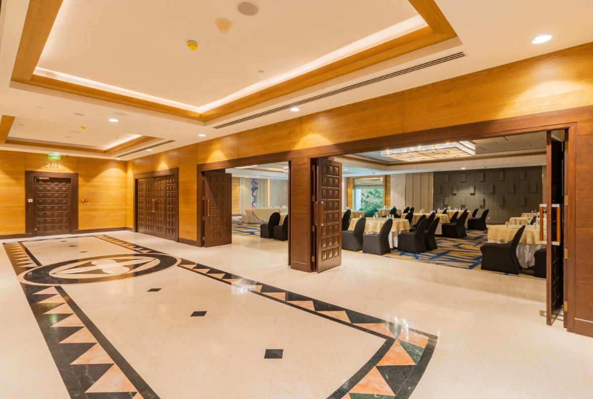 a large banquet hall with tables and chairs at Holiday Inn Agra MG Road an IHG Hotel in Agra