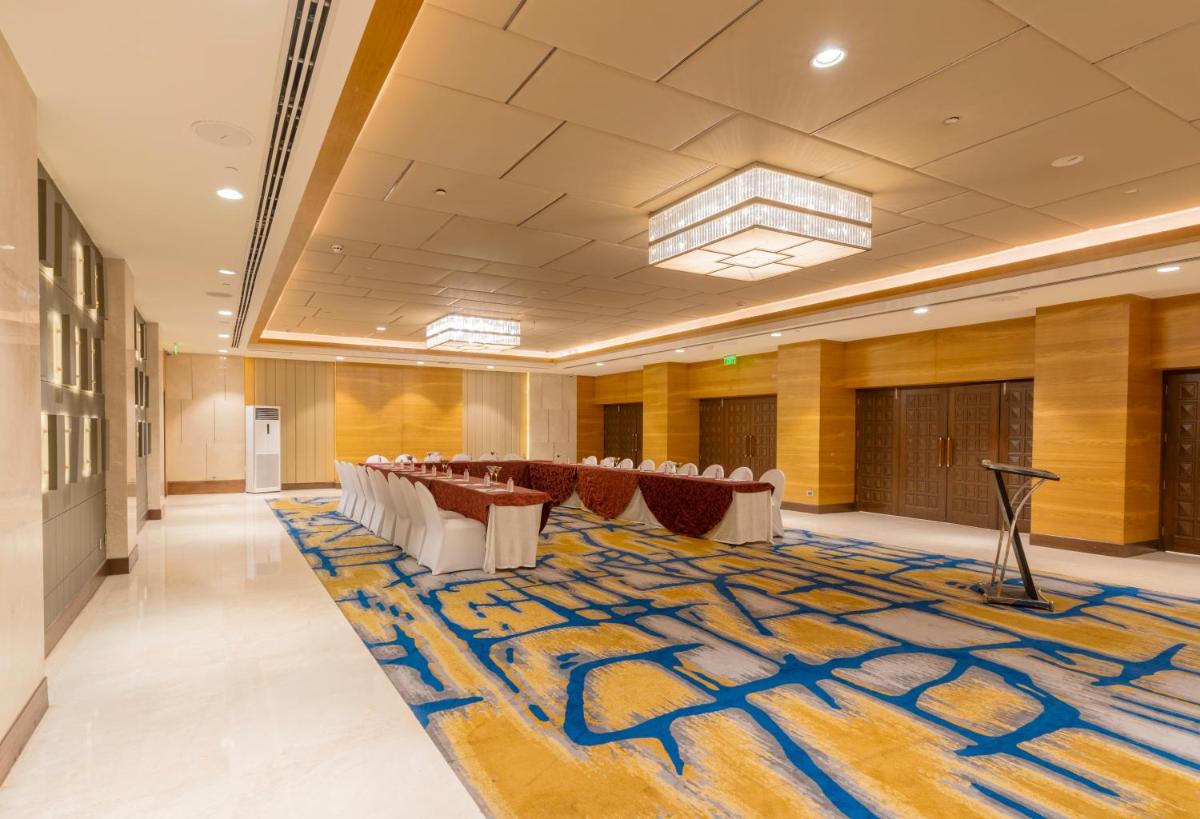 a conference room with tables and chairs and a rug at Holiday Inn Agra MG Road an IHG Hotel in Agra
