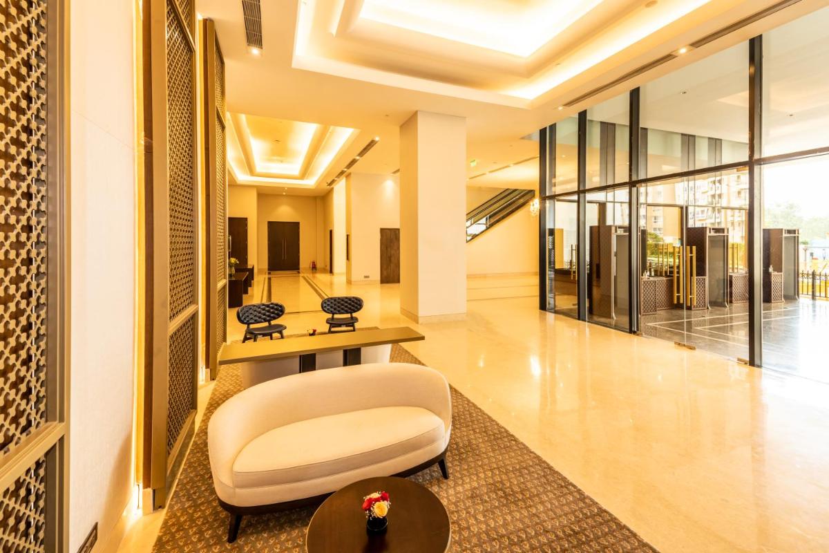 a lobby with a white chair and a table at The Leela Bhartiya City Bengaluru in Bengaluru a lobby with a white chair and a table at The Leela Bhartiya City Bengaluru in Bengaluru