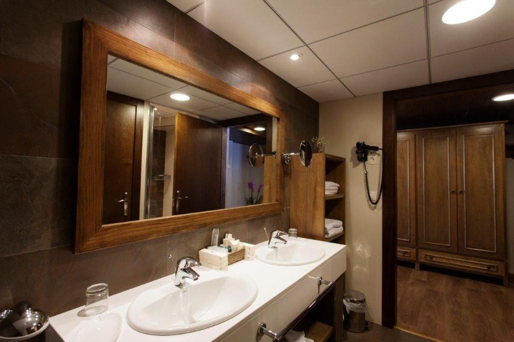 Un baño con dos lavabos y un espejo grande. en Tuc Blanc, en Baqueira Beret