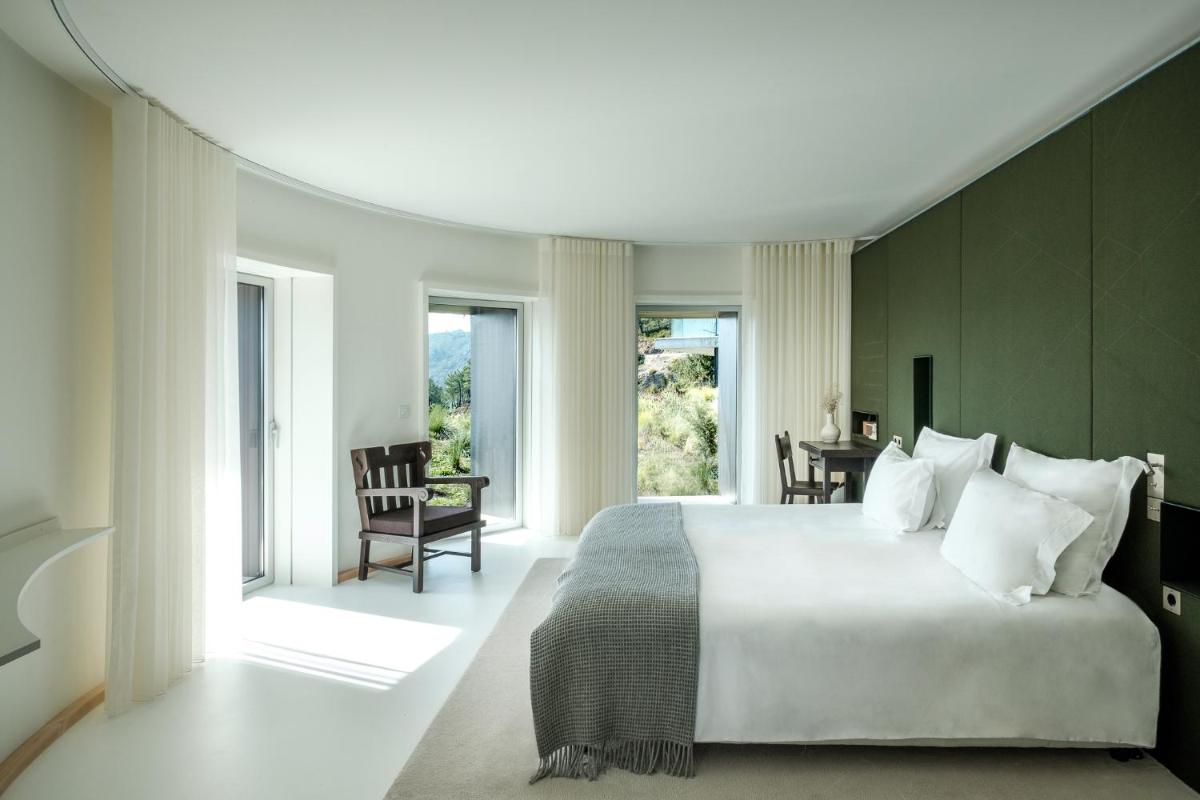 um quarto com uma cama grande, uma mesa e cadeiras em Casa de São Lourenço - Burel Panorama Hotel - member of Design Hotels em Manteigas