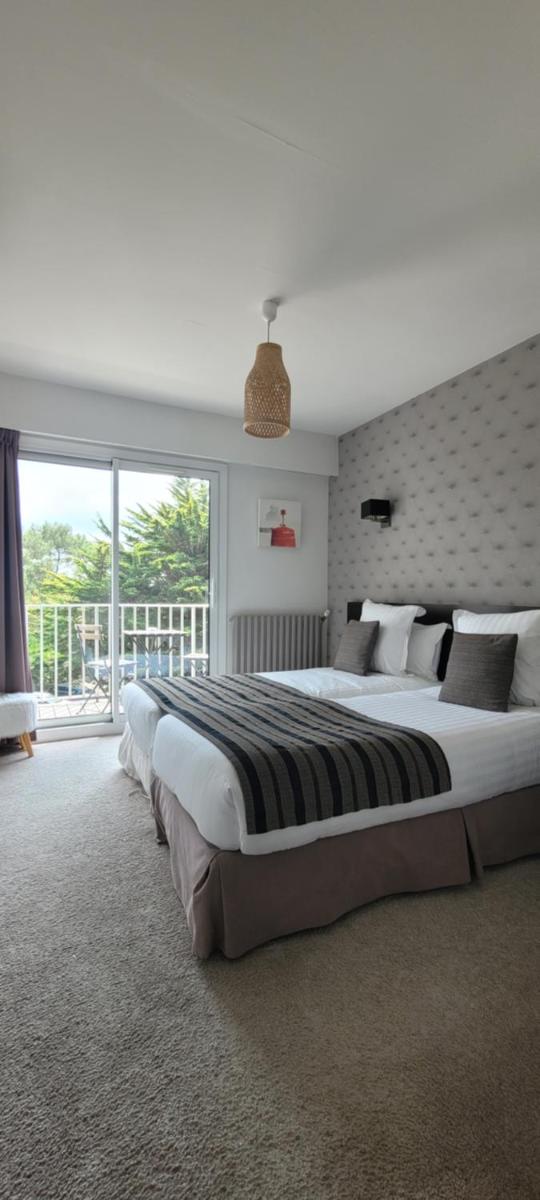 une chambre avec deux lits et une grande fenêtre dans l'établissement Le Galet Hotel & Spa, à Saint-Philibert