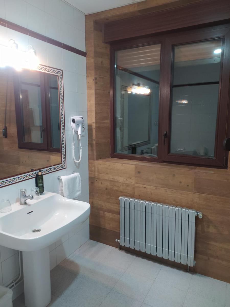 Un baño con un lavabo blanco y un espejo. en Balneario de Corconte, en Cabañas de Virtus 42 fotos más
