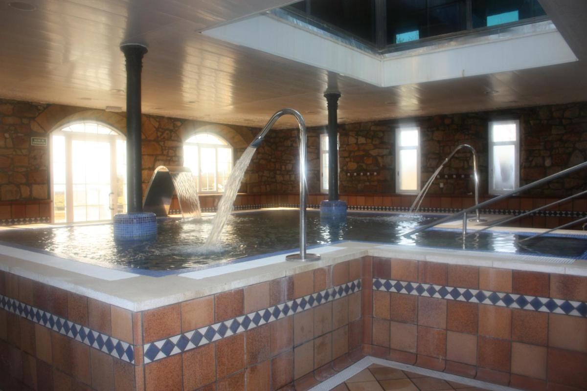 bañera con 2 grifos en una habitación en Balneario de Corconte, en Cabañas de Virtus