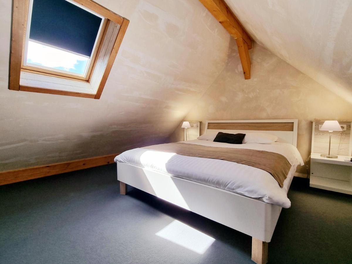 Un ou plusieurs lits dans un hébergement de l'établissement Hôtel Le Dormeur