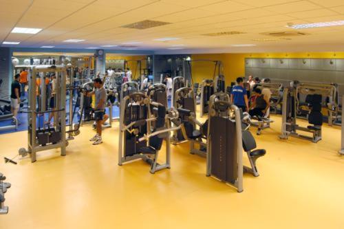 un gimnasio con filas de máquinas de correr y gente en él en Evenia Olympic Resort, en Lloret de Mar