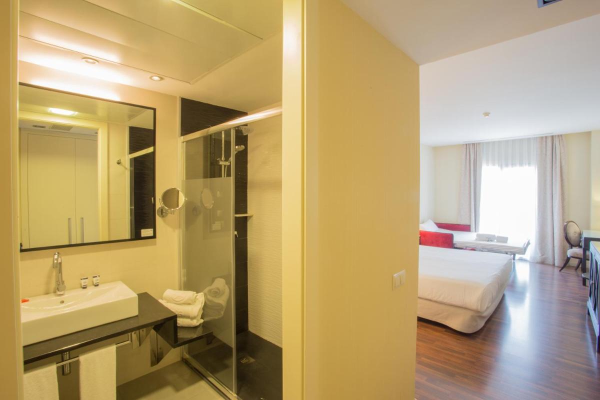 Un baño con lavabo y una cama en una habitación. en Hotel 525, en Los Alcázares