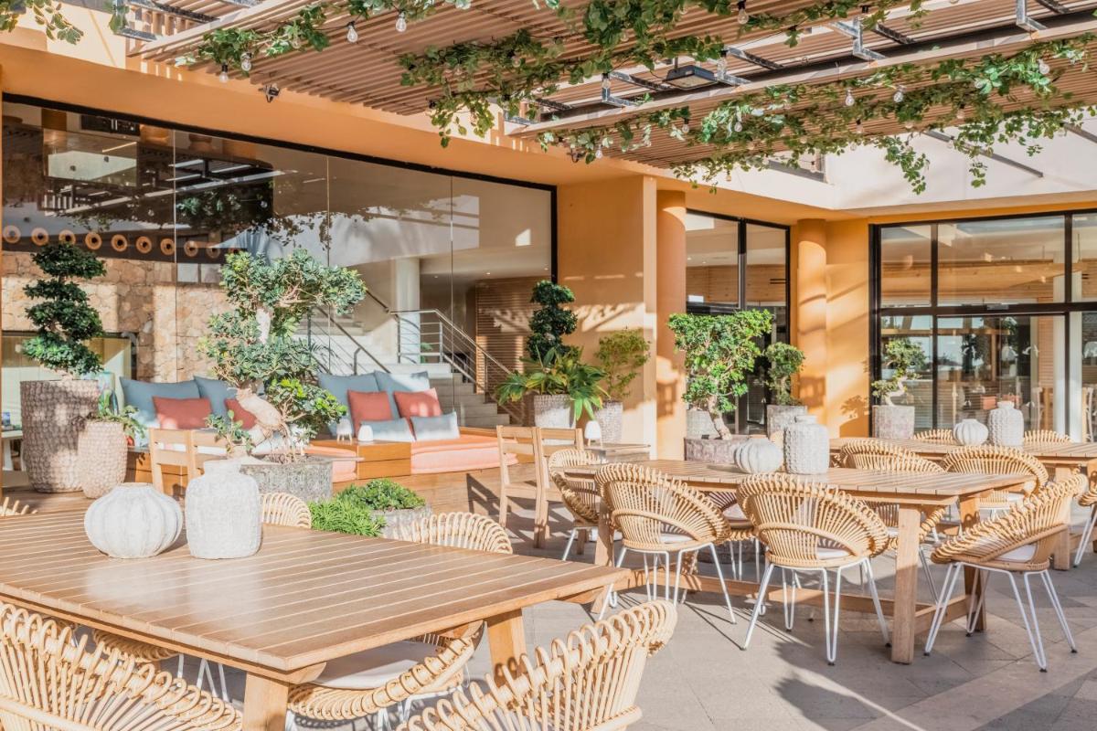 Un restaurante con mesas y sillas de madera y ventanas. en Iberostar Waves Playa Gaviotas All Inclusive, en Morro del Jable