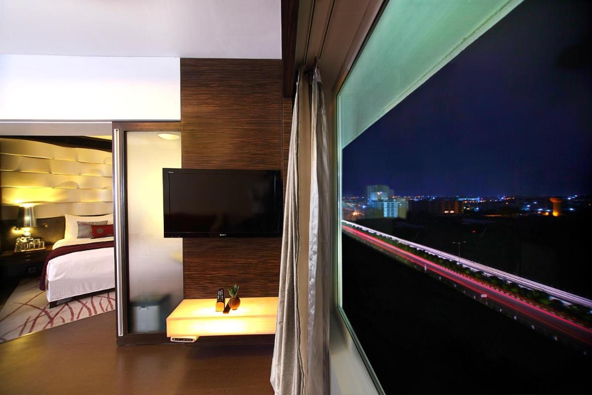 a room with a balcony with a view of a city at Fortune Select SG Highway, Ahmedabad - Member ITC Hotels' Group in Ahmedabad