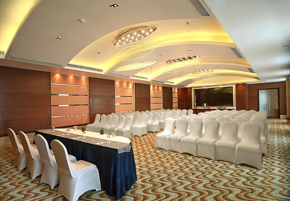 a conference room with white chairs and a table and a screen at Fortune Select SG Highway, Ahmedabad - Member ITC Hotels' Group in Ahmedabad
