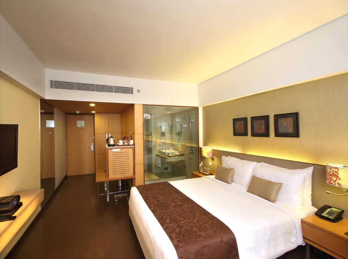 a hotel room with a large bed and a bathroom at Fortune Select SG Highway, Ahmedabad - Member ITC Hotels' Group in Ahmedabad