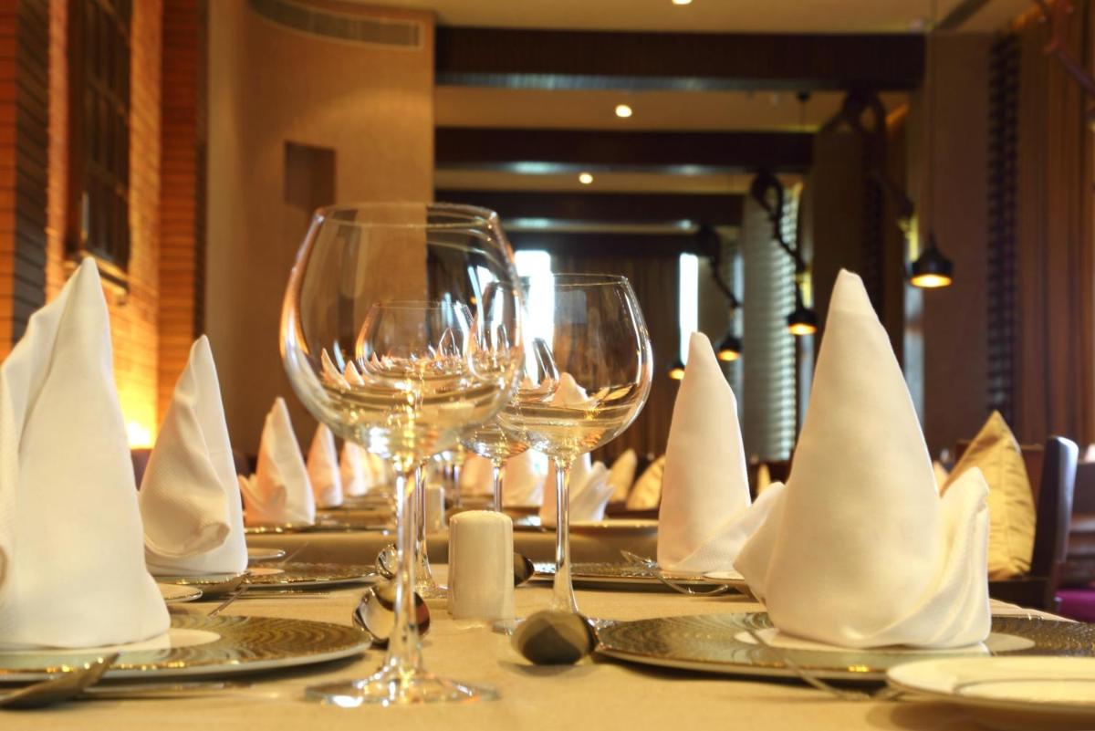 a table with wine glasses and napkins on it at Fortune Select SG Highway, Ahmedabad - Member ITC Hotels' Group in Ahmedabad