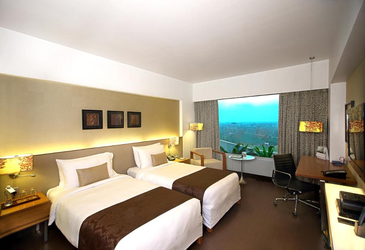a hotel room with two beds and a large window at Fortune Select SG Highway, Ahmedabad - Member ITC Hotels' Group in Ahmedabad