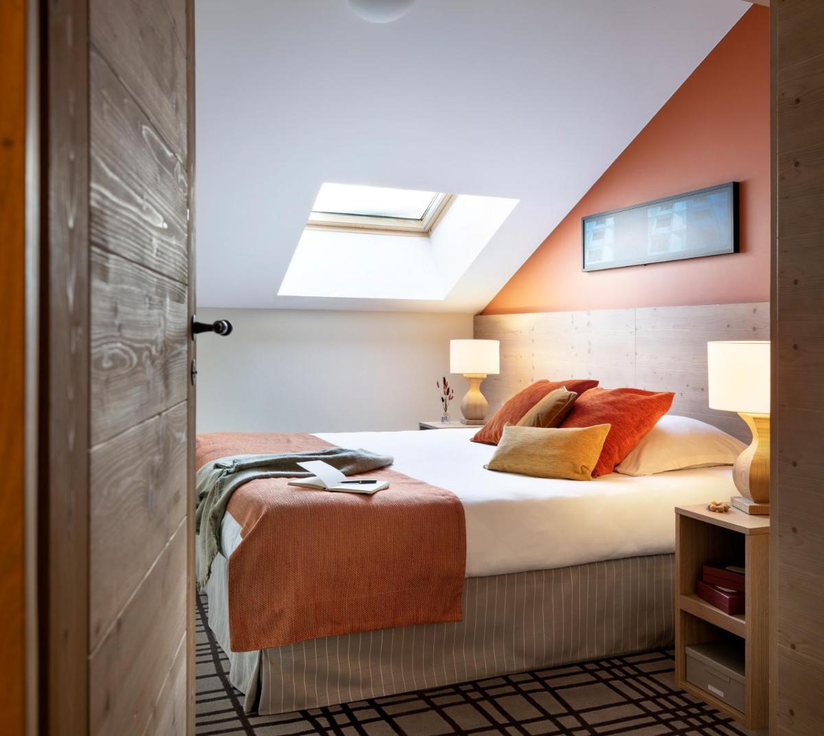 une chambre avec un lit et une lucarne dans l'établissement Résidence Pierre & Vacances Premium Les Terrasses d'Hélios, à Flaine