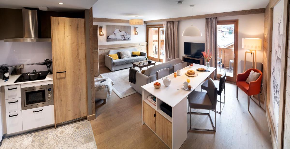 une cuisine et un salon avec une table et des chaises dans l'établissement Résidence Pierre & Vacances Premium L'Hévana, à Méribel