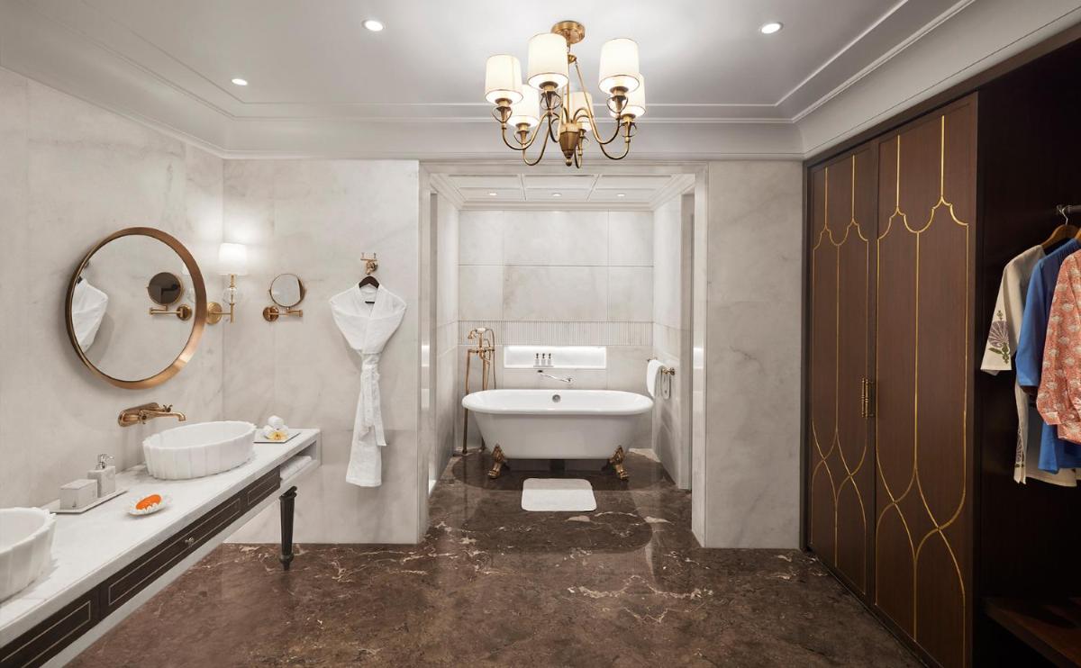 a bathroom with a white tub and a sink and a mirror at Sawai Man Mahal in Jaipur