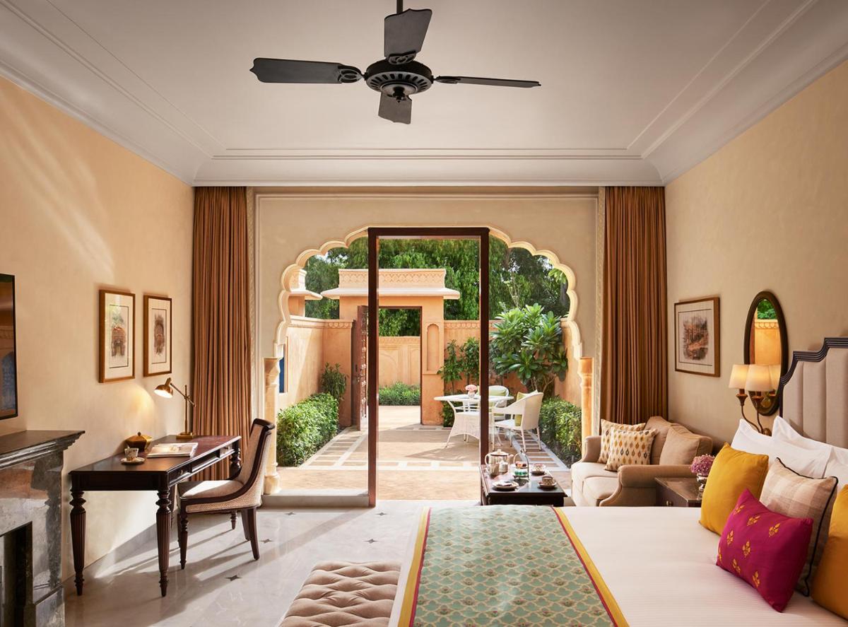 a living room with a bed and a mirror at Sawai Man Mahal in Jaipur