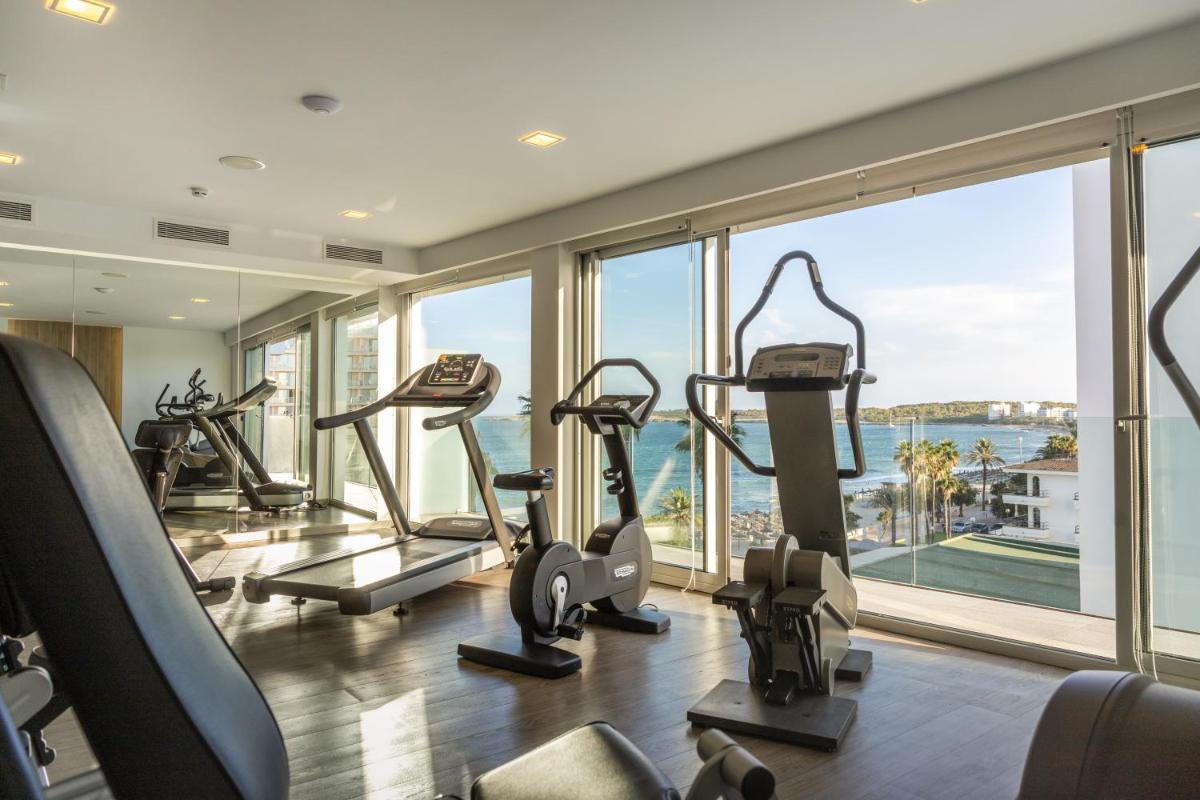 un gimnasio con máquinas de cardio y vistas al océano en Kyrat Amarac - Adults Only, en Cala Millor