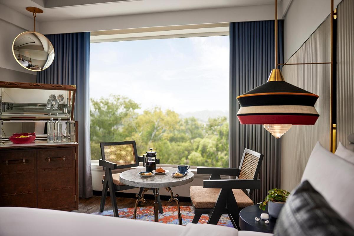 a living room with a table and chairs and a large window at Hyatt Centric Sector17 Chandigarh in Chandīgarh
