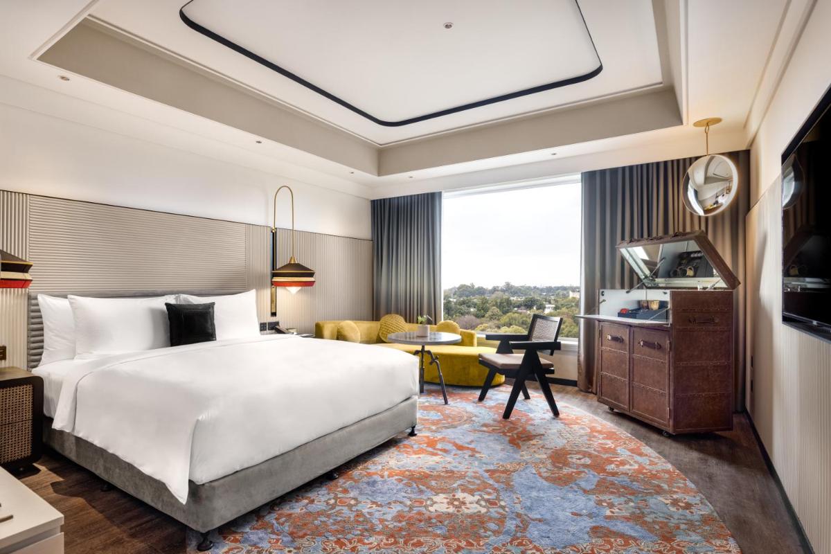 a bedroom with a large bed and a living room at Hyatt Centric Sector17 Chandigarh in Chandīgarh