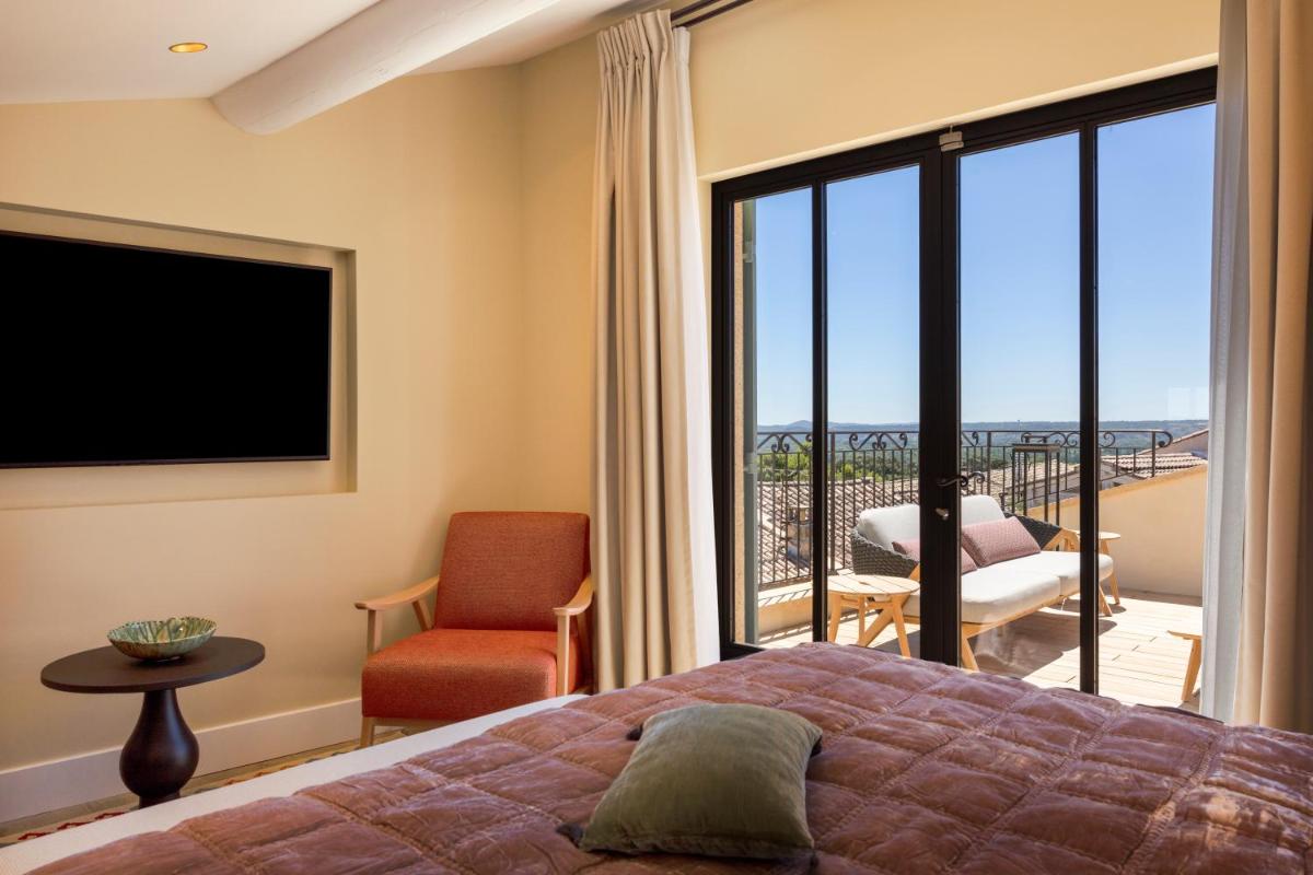 une chambre avec un lit et un balcon dans l'établissement Hotel La Mère Germaine, à Châteauneuf-du-Pape