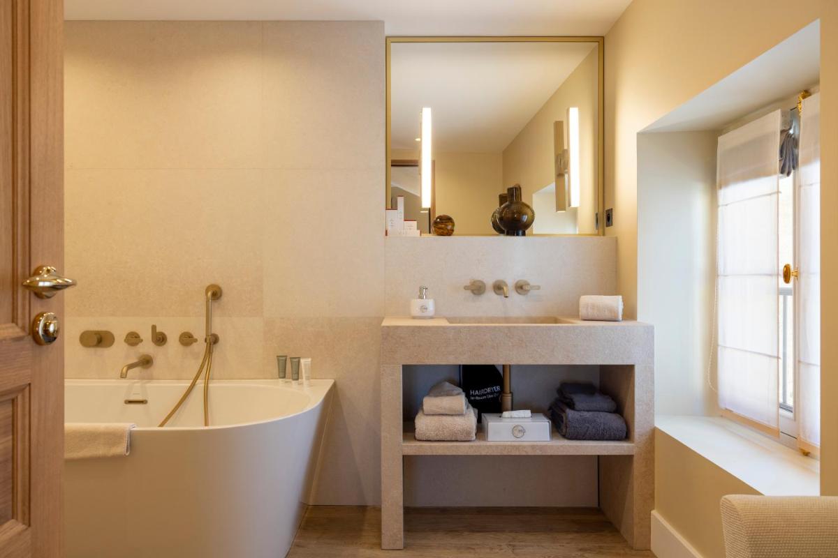 une salle de bain avec une baignoire et un lavabo dans l'établissement Hotel La Mère Germaine, à Châteauneuf-du-Pape