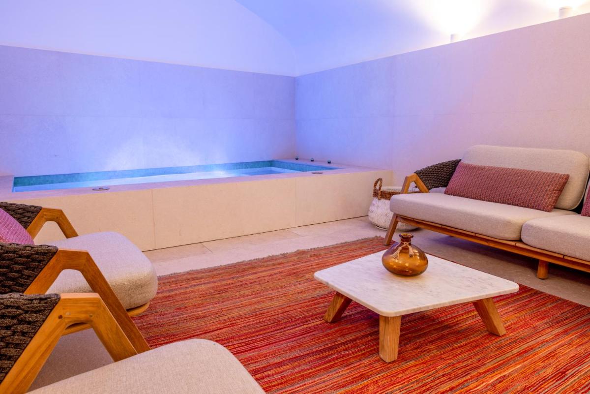 - un salon avec un canapé et une baignoire dans l'établissement Hotel La Mère Germaine, à Châteauneuf-du-Pape