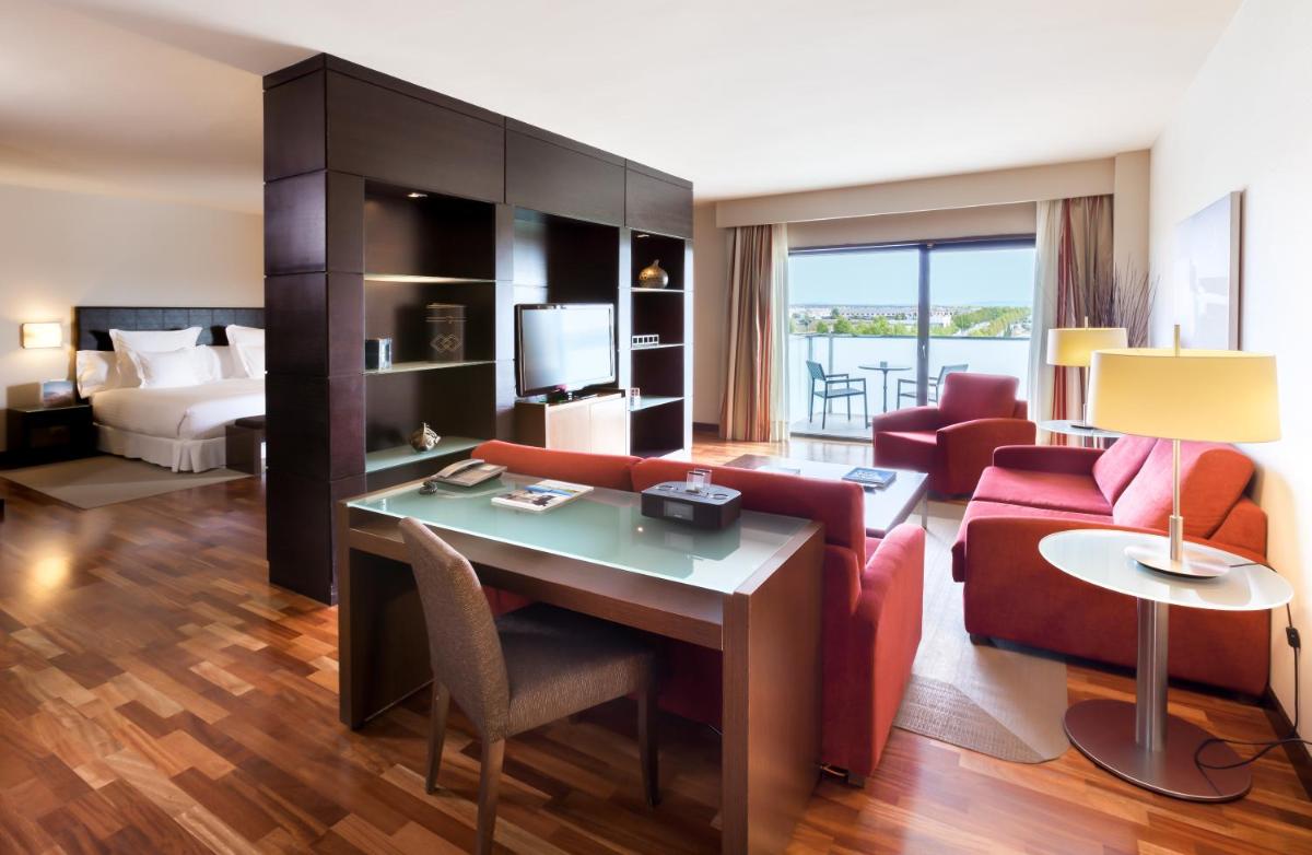 Suite de hotel con sala de estar y dormitorio en Occidental Aranjuez, en Aranjuez