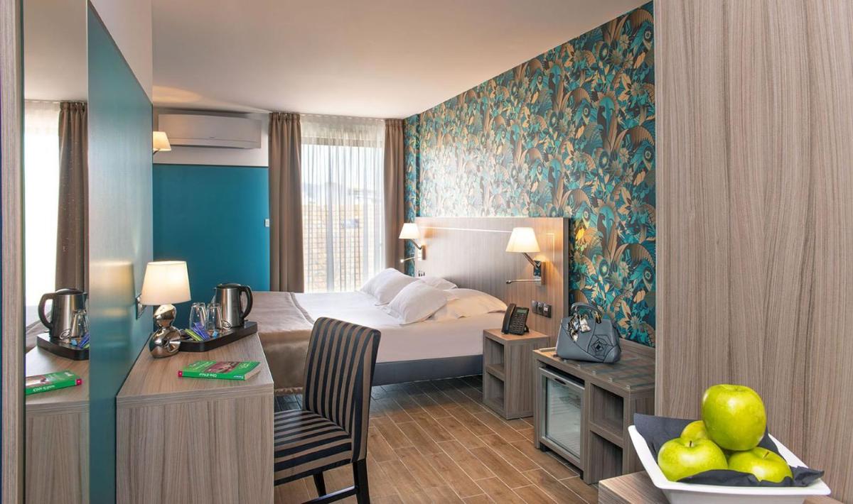une chambre d'hôtel avec un lit et un bureau dans l'établissement Unique Hôtel Résidence & Spa, à Saint-Raphaël