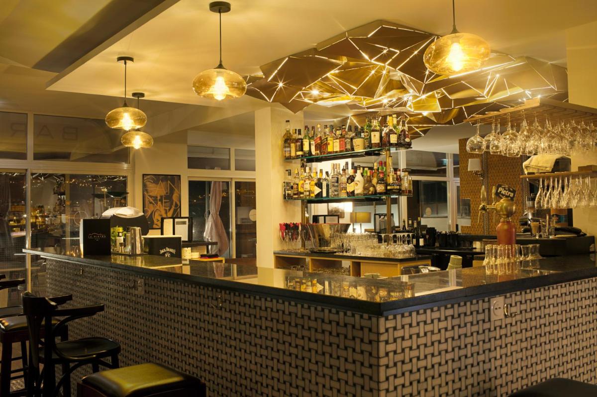 un bar dans un restaurant avec des verres sur le comptoir dans l'établissement Hotel La Pietra Restaurant & Spa, à LʼÎle-Rousse